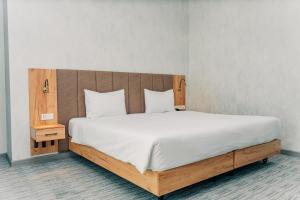 a bedroom with a large bed with white sheets and pillows at Hanzade Palace in Samarkand