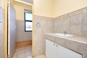 a bathroom with a sink and a shower at Airport Lodge Hotel in Kempton Park +35 photos