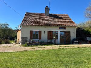 a small white house with a bench in front of it at Chez Karen in Montlay-en-Auxois