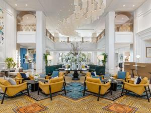 a lobby with chairs and tables and a chandelier at Sofitel Ras Al Khaimah Al Hamra Beach Resort in Ras al Khaimah