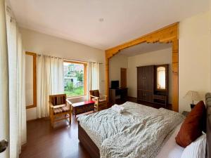 a bedroom with a large bed and a table and chairs at Niri-la Ladakh Leh in Leh