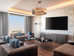 a living room with a couch and a tv at Novotel Riyadh Sahafa in Riyadh +286 photos
