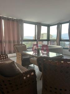 a living room with two tables and chairs and windows at Mila Todorovska in Star Dojran +3 photos