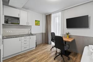 a hotel room with a desk and a tv at AJO Apartments - Vetmed - Self-Check-in in Vienna