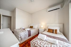 two beds in a room with white walls at HolidaysPT - Luanda - 2 Bedroom Apartment in Olhão