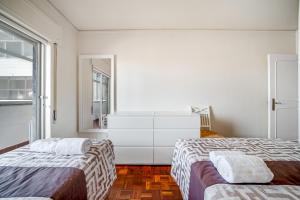 a bedroom with two beds and a dresser at HolidaysPT - Luanda - 2 Bedroom Apartment in Olhão