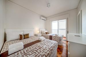 a bedroom with two beds and a window at HolidaysPT - Luanda - 2 Bedroom Apartment in Olhão