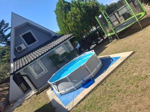 a small house with a swimming pool in front of it at Vikendica DUNAV in Golubac