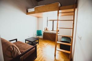 ウラジオストクにあるゲストハウス ウラジオストクの二段ベッドとソファが備わる小さな客室です。