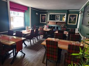 a dining room with wooden tables and chairs at The Red Lion Hotel in Oakford