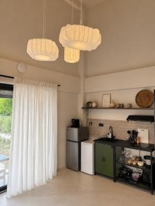 a kitchen with a stove and a refrigerator and two lights at athanasian side sea view home in Polychrono