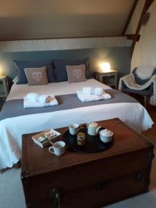 a bedroom with a bed with a table with cups and a tray at Chez Mathilde in Eaux-Puiseaux