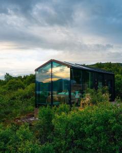 a glass house in the middle of a field at WonderInn Arctic in Utstrand +24 photos