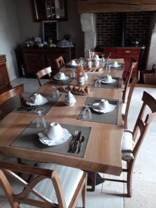 a long wooden table with plates and napkins on it at Chez Mathilde in Eaux-Puiseaux