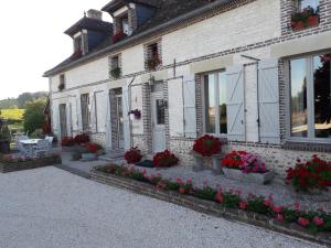 a white brick building with flowers in front of it at Chez Mathilde in Eaux-Puiseaux