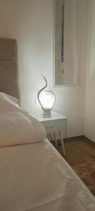 a white bed with a lamp on a table at Victor spa Apartment in Veliko Gradište