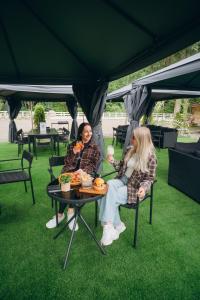 two women sitting at a table under a tent at NACHIKU Bukovel Resort & SPA in Palyanytsya