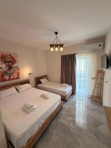 a bedroom with two beds and a painting on the wall at Rafael & Sofia Luxury Suites in Ammoudia