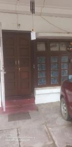 a garage with two doors and a car parked in front at THUBE Saheb B&B in Jabalpur
