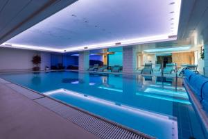 a large swimming pool with chairs in a building at Hotel Venezia in Rocca Pietore