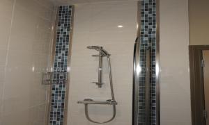 a shower in a bathroom with black and white tiles at The Dolphin in Whitby