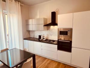 a kitchen with white cabinets and a stove top oven at Appartamenti Colombo in Arma di Taggia