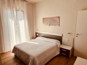 a small bedroom with a bed and a window at Appartamenti Colombo in Arma di Taggia
