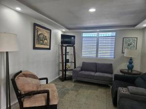 a living room with a couch and a chair at Spacious Beachfront Escape at Playa Guayanes for Large Groups in Yabucoa