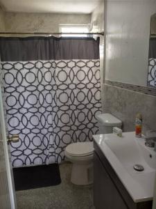 a bathroom with a toilet and a shower curtain at Spacious Beachfront Escape at Playa Guayanes for Large Groups in Yabucoa +13 photos