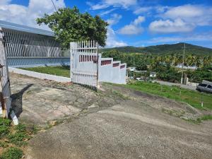 a white fence on the side of a road at Spacious Beachfront Escape at Playa Guayanes for Large Groups in Yabucoa