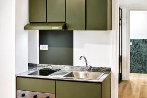 a kitchen with green cabinets and a sink at Residenza Ximenes in Palermo +16 photos