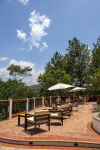 a patio with tables and chairs and umbrellas at Rincon del Buey Resort in Copán Ruinas