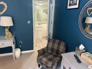 a living room with a chair and blue walls at The Red Lion Hotel in Oakford