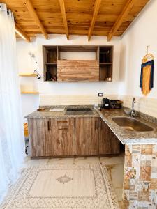 a kitchen with wooden cabinets and a sink at Bedro Rooftop Studio 2 Private Balcony Sea View 30 Sec to Sea in Dahab
