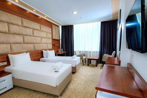 a hotel room with two beds and a television at Kule Hotel & Spa in Gaziantep
