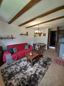 a living room with a red couch and a table at Casa Vacanze Ginger in Grange Sises