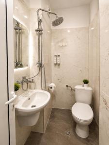 a white bathroom with a toilet and a sink at AnaBella Apartments Gabrovo in Gabrovo +6 photos