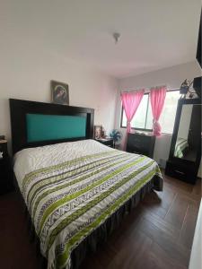a bedroom with a bed with a blanket on it at Alojamiento el Toro in Gómez