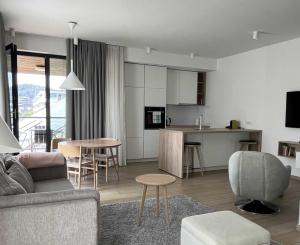 a living room and kitchen with a couch and a table at REGENTova SUITES Ljubljana in Ljubljana