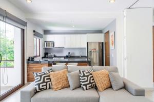 a living room with a couch and a kitchen at Bright 1 BD with private Terrace near TULUM in Akumal