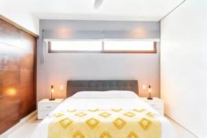 a bedroom with a large bed and two night stands at Bright 1 BD with private Terrace near TULUM in Akumal