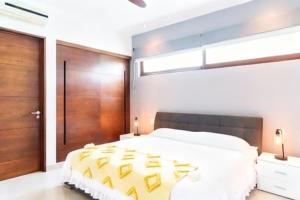 a bedroom with a large bed and a wooden door at Bright 1 BD with private Terrace near TULUM in Akumal +14 photos