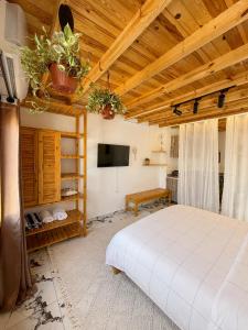a bedroom with a white bed and a wooden ceiling at Bedro Rooftop Studio 2 Private Balcony Sea View 30 Sec to Sea in Dahab +15 photos