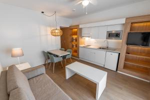 a living room with a couch and a table and a kitchen at Los Olivos Beach Resort in Adeje