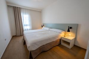 a bedroom with a large bed and a night stand at Los Olivos Beach Resort in Adeje