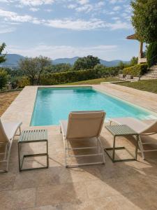 a swimming pool with two lounge chairs and a table at Majordoms Vila in Cornellá de Terri