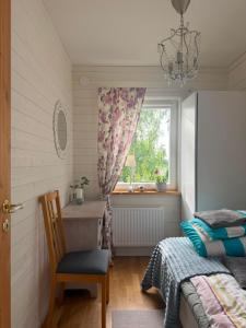 a bedroom with a bed and a window and a chair at Charming cottage on Kvegero in Gnesta