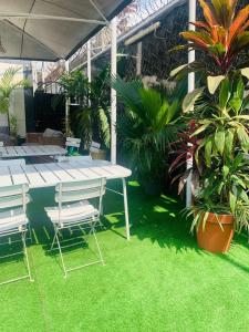 a patio with a table and chairs and plants at Hotel Omnisport in Limbe