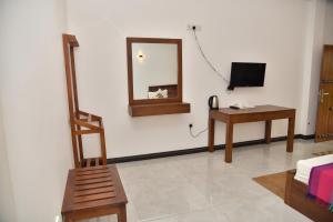 a living room with a mirror and a chair at Buddika Safari & Resort in Udawalawe +54 photos