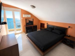 a bedroom with a bed with a television and a desk at Penthouse Bečići Apartament in Bečići +11 photos